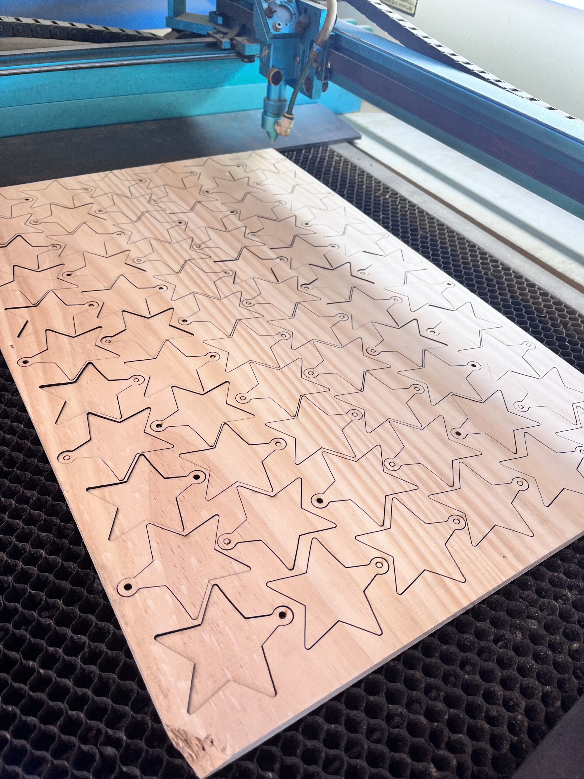 Placa de madera con múltiples figuras cortadas en producción en serie